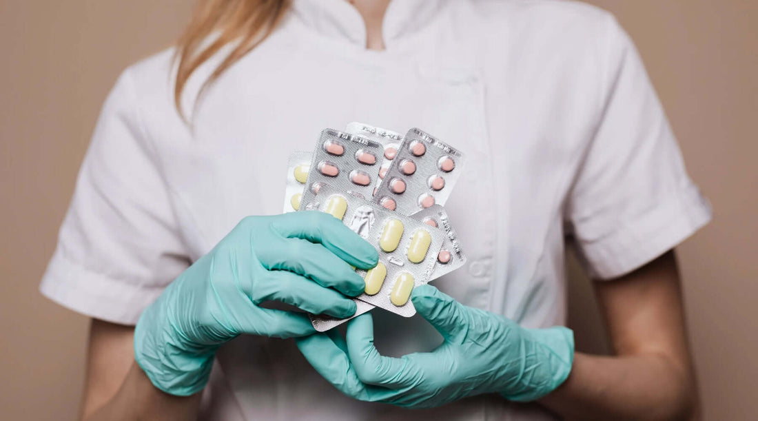 photo d'une professionnelle de santé avec des gants et des plaquettes de médicaments en main